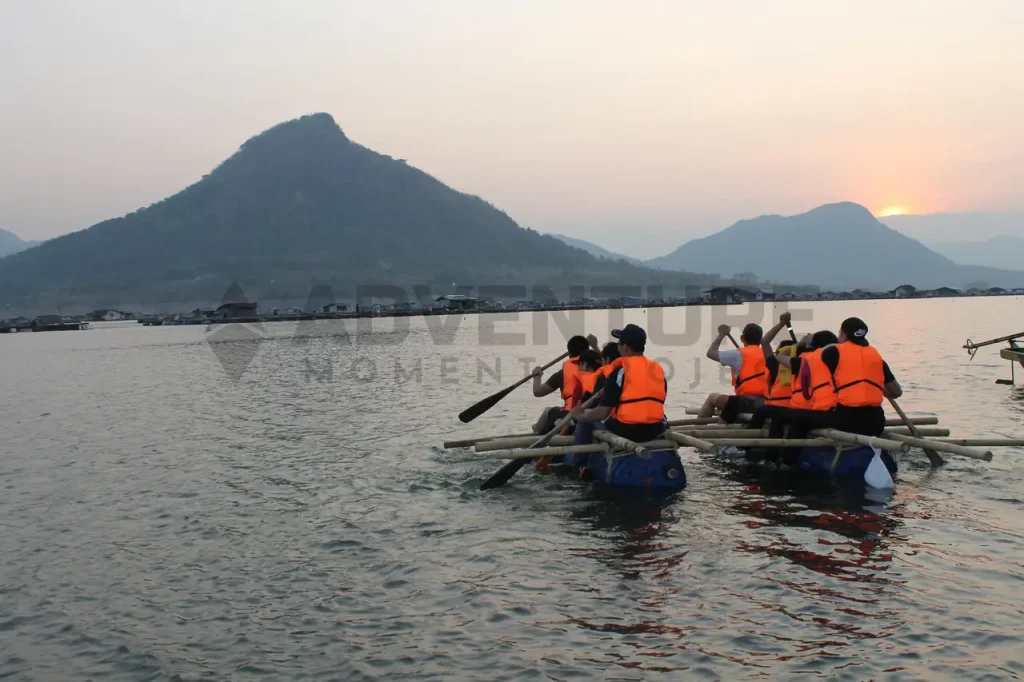 Team building by rafting in group at sunset on water