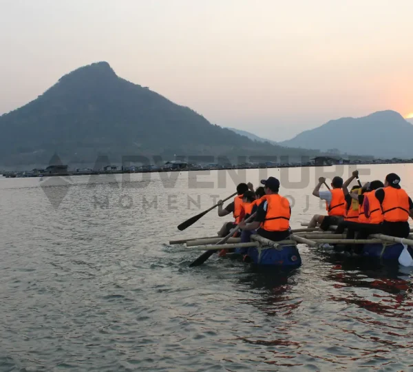 Team building by rafting in group at sunset on water